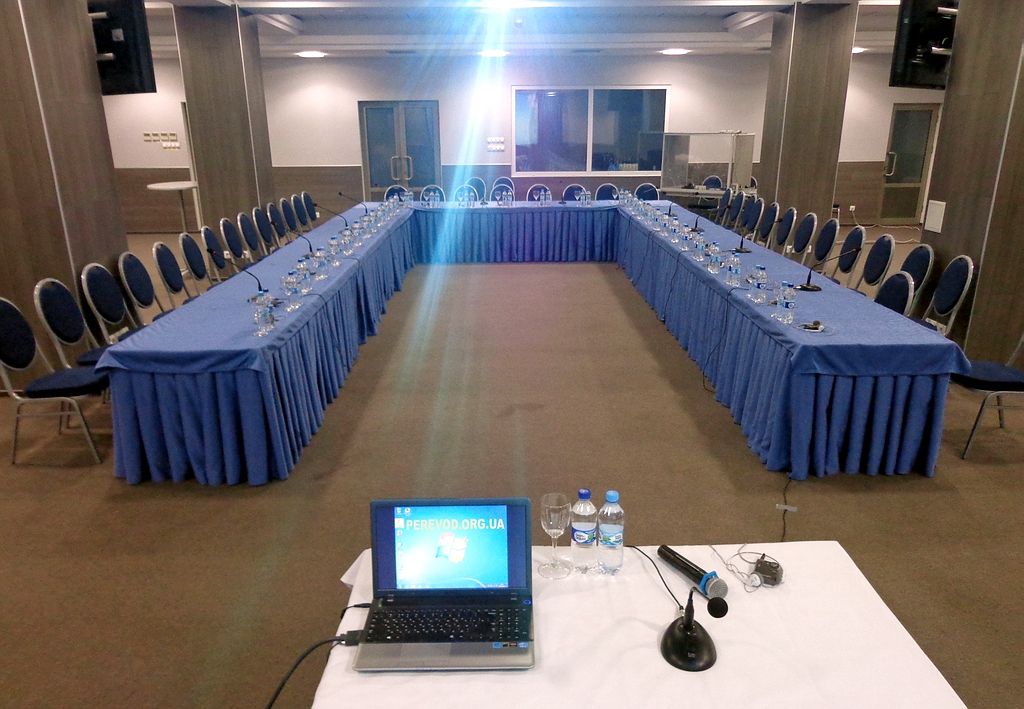 Общий вид зала для конференции, кабина для переводчиков, наушники для слушателей перевода, микрофоны