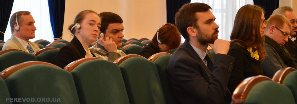 Журналисты и наблюдатели слушают синхронный перевод с английского на украинский язык.