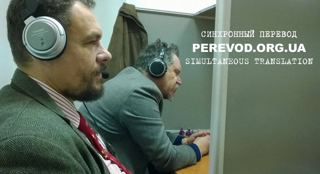 Переводчики-синхронисты в процессе устного перевода английского и украинского языков на семинаре в Киеве.