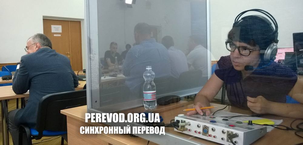 Переводчик-синхронист в кабине во время работы в зале агентства Укринформ